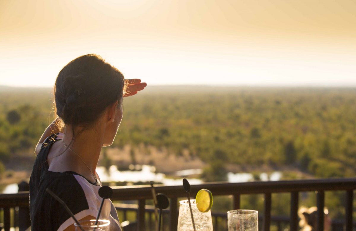 Guest at Victoria Falls Safari Lodge deck at sunset